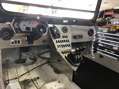 1992 Jeep Wrangler - The interior of a custom-built vehicle shows a metal dashboard with multiple gauges, switches, and a central console with gear shifters. Th…