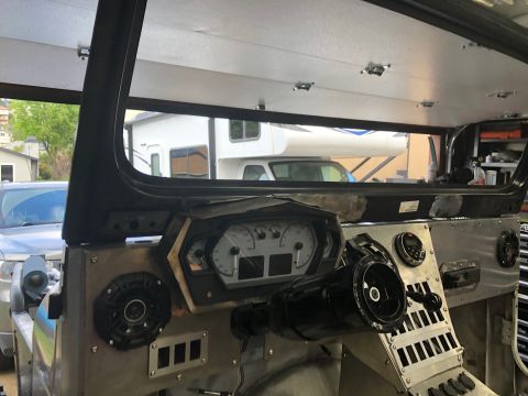 1992 Jeep Wrangler - Interior view of a custom-built vehicle dashboard featuring a digital gauge cluster, a steering wheel, and speakers. The vehicle appears to…