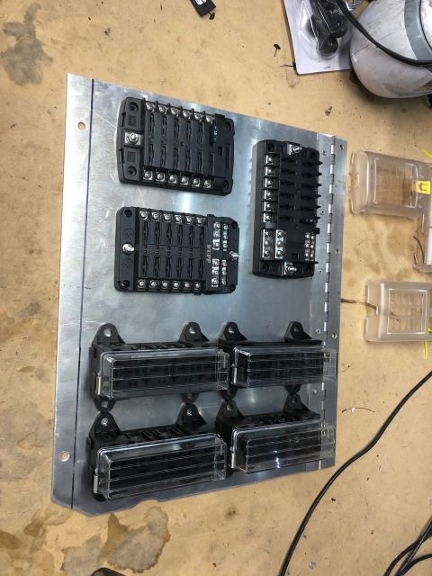1992 Jeep Wrangler - A metal panel is mounted with several automotive fuse blocks and fuse holders. The fuse blocks are black and have multiple slots for fuses,…