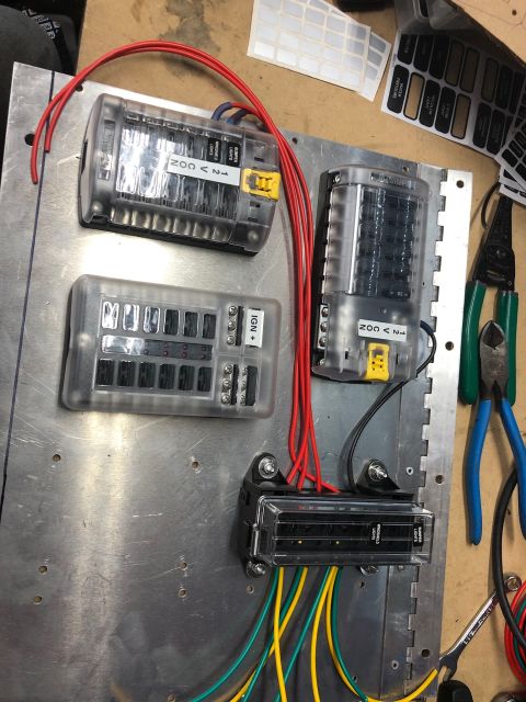 1992 Jeep Wrangler - A close-up view shows a custom electrical fuse block setup mounted on a metal panel, with several fuse boxes connected by red, yellow, and…