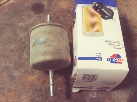 1996 Ford Bronco - A used Purolator F64711 fuel filter sits next to a new CARQUEST fuel filter box. The box displays an image of the filter inside and text in…