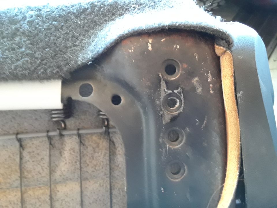 Close-up of vehicle seat frame with springs and upholstery.