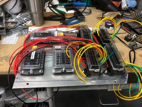 1992 Jeep Wrangler - A custom wiring harness for a 1992 Jeep Wrangler is laid out on a workbench, featuring multiple fuse blocks connected with red, yellow, and…