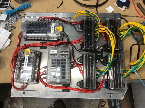1992 Jeep Wrangler - A custom electrical fuse block panel with multiple fuse boxes and wiring is mounted on a metal surface, likely for a vehicle modification.…