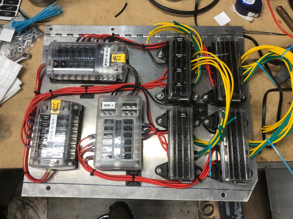 Custom vehicle electrical fuse block panel with multiple fuse boxes and wiring.