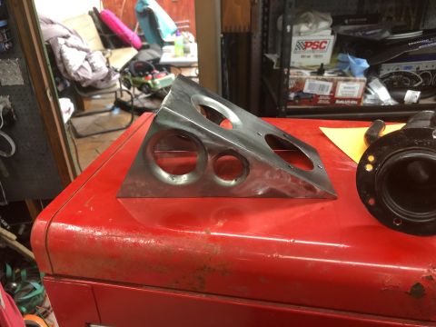 1992 Jeep Wrangler - A triangular metal bracket with several circular cutouts rests on a red metal toolbox. To the right, a black circular part with a flange an…