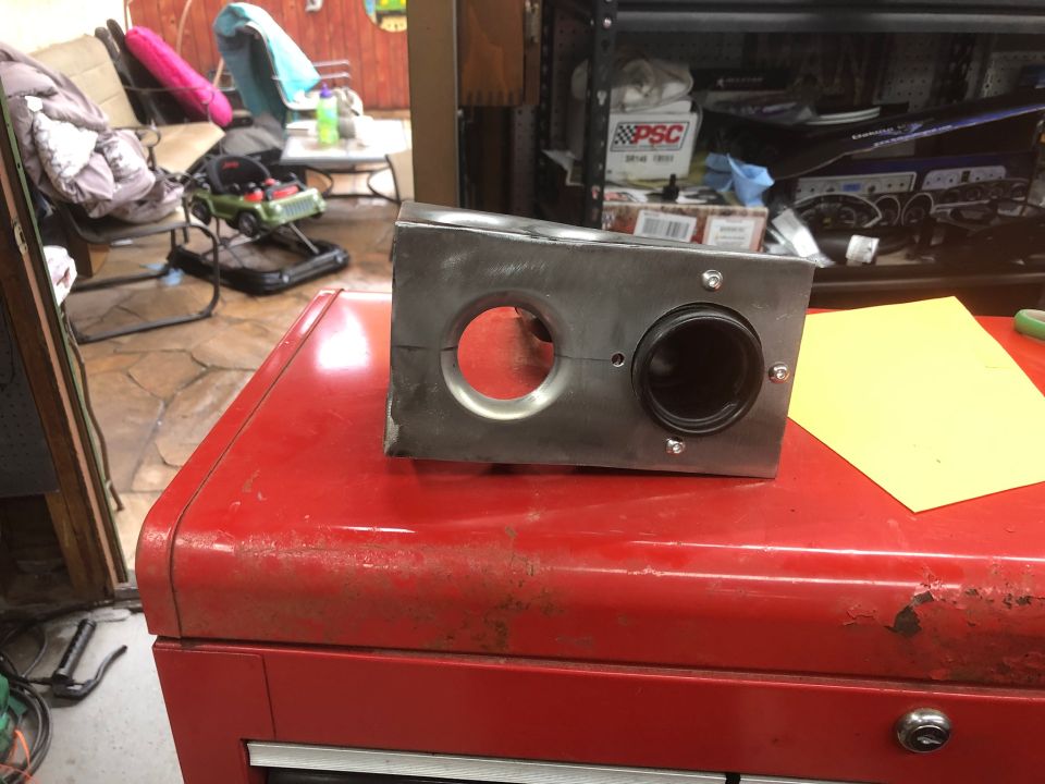 Custom metal automotive part with two openings on a red toolbox.