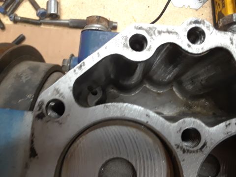 1985 Ford Bronco - A close-up view of a heavily machined metal engine component, likely part of a supercharger or similar apparatus, with visible bolt holes a…