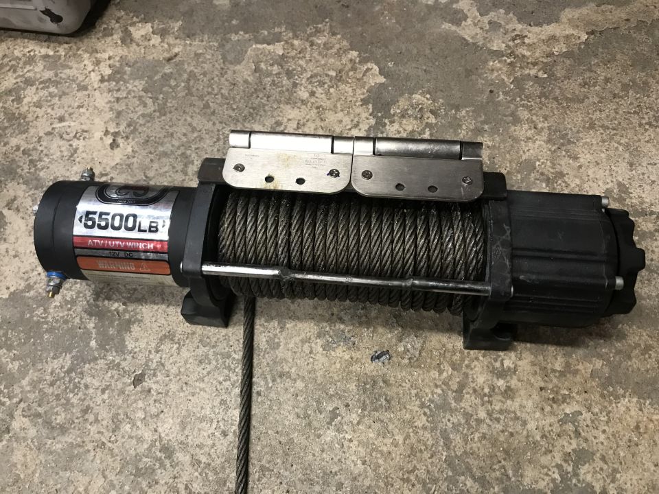 Black 5500lb ATV/UTV winch with steel cable on concrete.