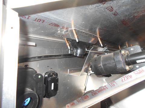 1992 Ford Bronco - Close-up view of mechanical components and wiring inside a vehicle, possibly an engine bay or undercarriage, with visible metal sheeting an…