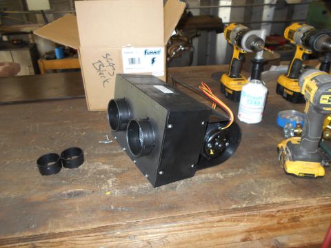 1992 Ford Bronco - A black HVAC unit with two circular vents is on a wooden workbench, next to a cardboard box and several power tools. A can of Freon 134a is…