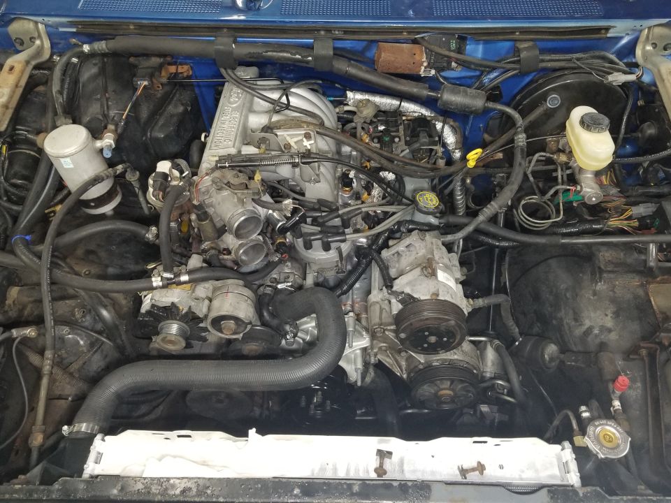 I still have to run the silicone vacuum lines; mount the charcoal canister, and install the plastic reservoir; but the engine is pretty much done. It passed the coolant pressure test, but the PSF needs to be topped-up after the engine runs.
IF THE IMAGE IS TOO SMALL, click it.

Still to do:
- horns
- fuel pump access
- pinion bearing preload
- ATF filter
- swingaway bushing