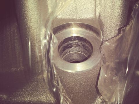 1996 Ford Bronco - Close-up view of a machined metal cylindrical part, possibly a bearing housing, with visible wear marks inside the bore. The part is partia…