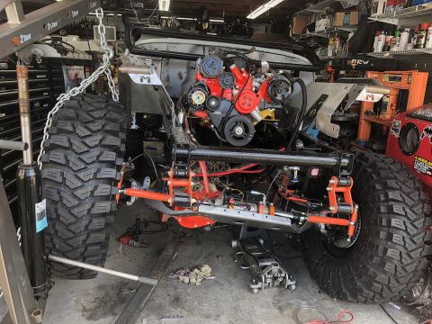 1992 Jeep Wrangler - Custom Jeep Wrangler chassis with engine and suspension modifications in a garage setting.