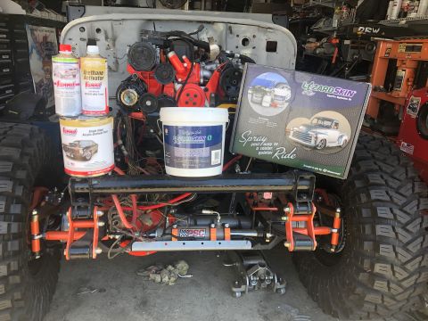 1992 Jeep Wrangler - A Jeep Wrangler chassis is shown with its engine and various automotive products laid out around it.
