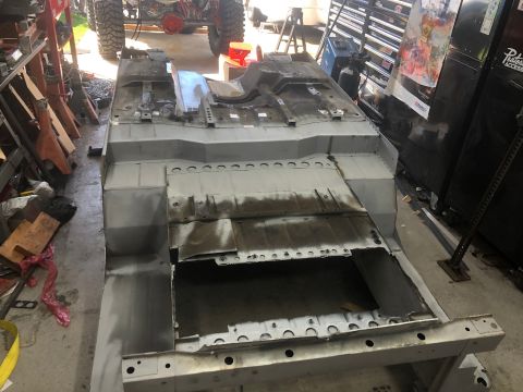 1992 Jeep Wrangler - The chassis of a vehicle is shown in a workshop, possibly undergoing restoration or modification.