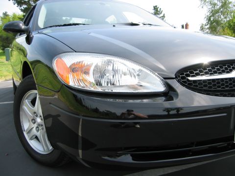 2002 Ford Taurus - Front view of a black 2002 Ford Taurus, its distinctive honeycomb grille and clear headlights.