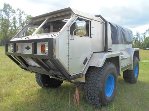 1992 Ford Bronco - This custom truck features a unique aluminum body and large off-road tires with blue rims.