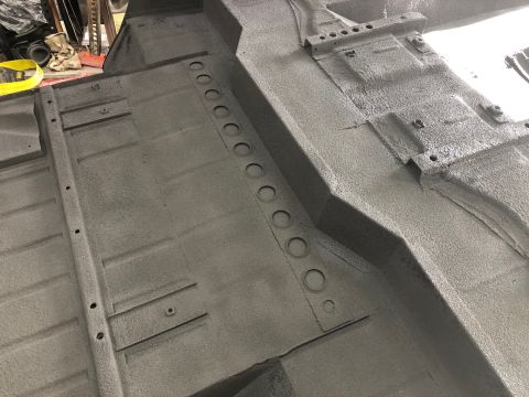 1992 Jeep Wrangler - The undercarriage of a vehicle shows a gray, textured finish with various structural components and mounting holes.