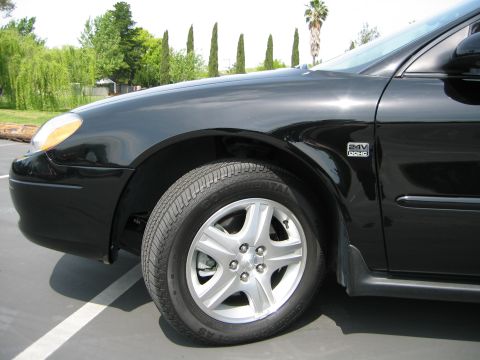 2002 Ford Taurus - Close-up of the front passenger side of a black 2002 Ford Taurus.