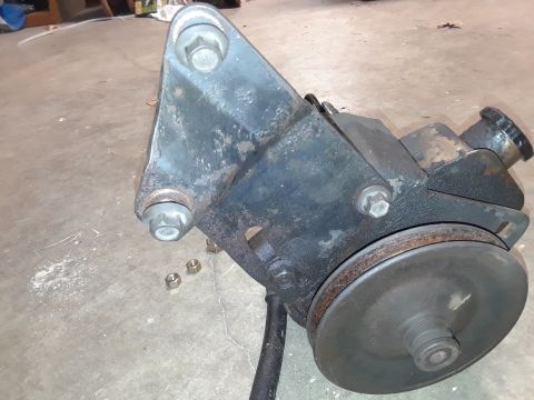 1994 Ford Bronco - This power steering pump assembly, a pulley and mounting bracket, is shown removed from a vehicle.