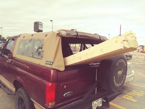 1996 Ford Bronco - 1996 Ford Bronco carrying lumber, spare tire visible on the rear.