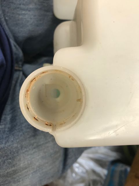 1979 Ford Bronco - The opening of a plastic fluid reservoir shows signs of rust around the rim.
