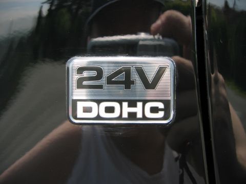 2002 Ford Taurus - A close-up of a 24V DOHC badge on a black vehicle's exterior.