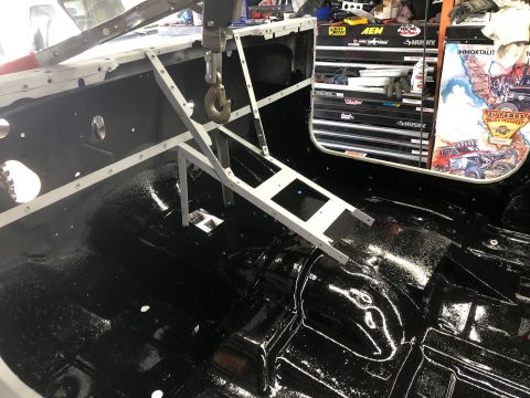 1992 Jeep Wrangler - The interior of a vehicle is shown with a freshly painted black floor and a metal frame assembly overhead, suggesting ongoing work.
