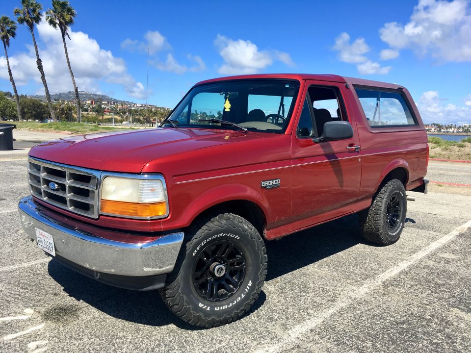 Red 1996 Ford Bronco SUV parked on asphalt, three-quarter front view