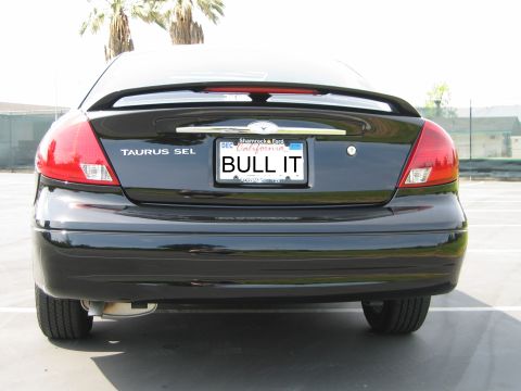 2002 Ford Taurus - Rear view of a black 2002 Ford Taurus SEL sedan with a spoiler and custom license plate.