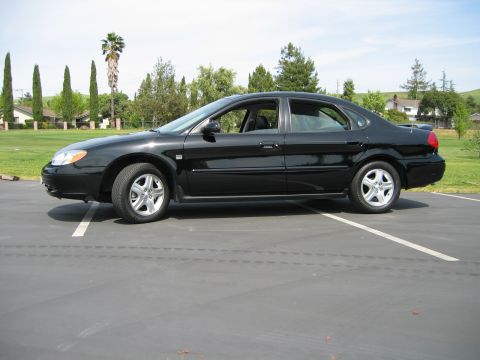 2002 Ford Taurus - Side profile of a black 2002 Ford Taurus sedan parked outdoors on a sunny day.