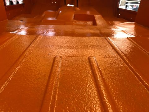1992 Jeep Wrangler - The interior floor of a vehicle has been coated in a textured orange paint.