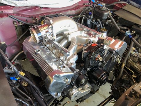 1992 Ford Crown Victoria - The engine bay shows a modified V8 engine with an aftermarket intake and chrome valve covers.