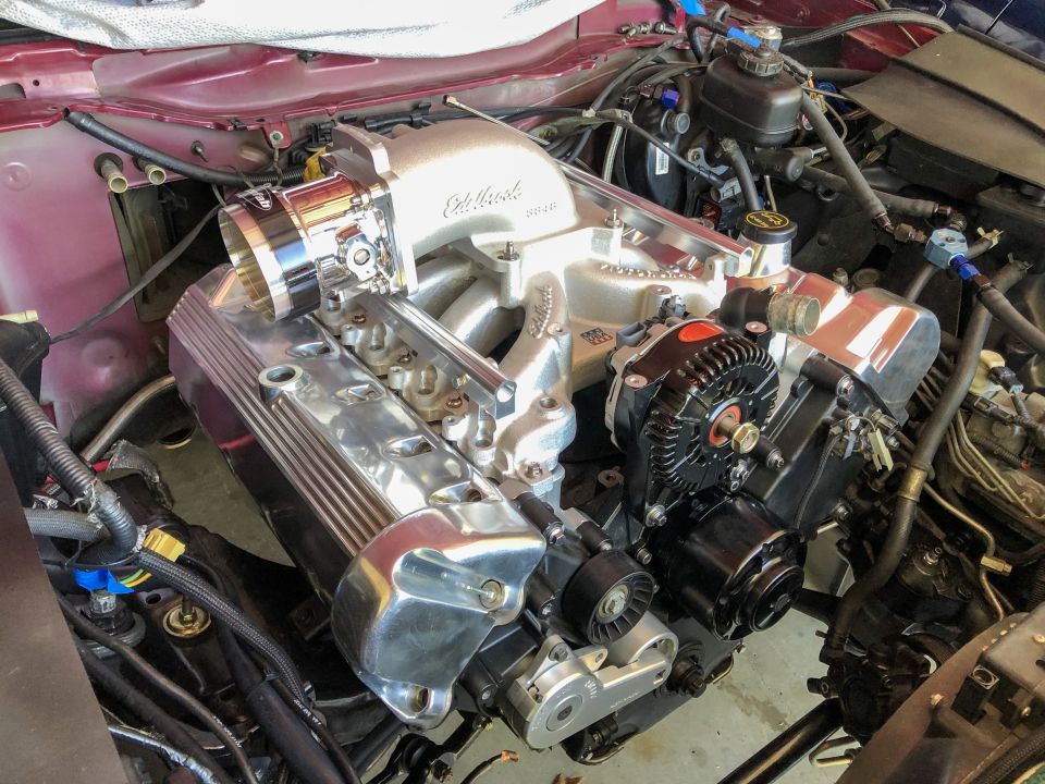 Close-up of a V8 engine with an Edelbrock intake manifold and chrome valve covers