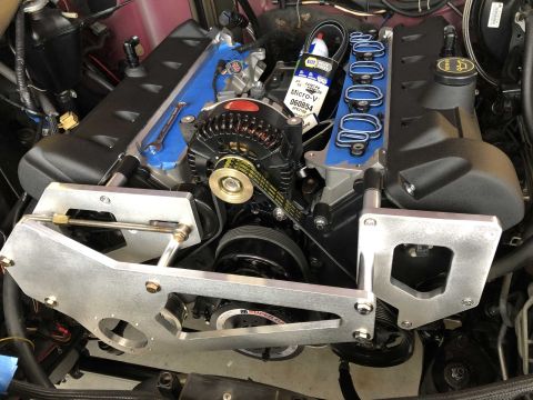 1992 Ford Crown Victoria - Close-up of an engine bay with focus on the alternator and belt system during a rebuild.