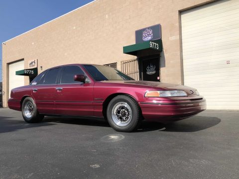 1992 Ford Crown Victoria - Maroon 1992 Ford Crown Victoria with aftermarket wheels parked outside a commercial building.