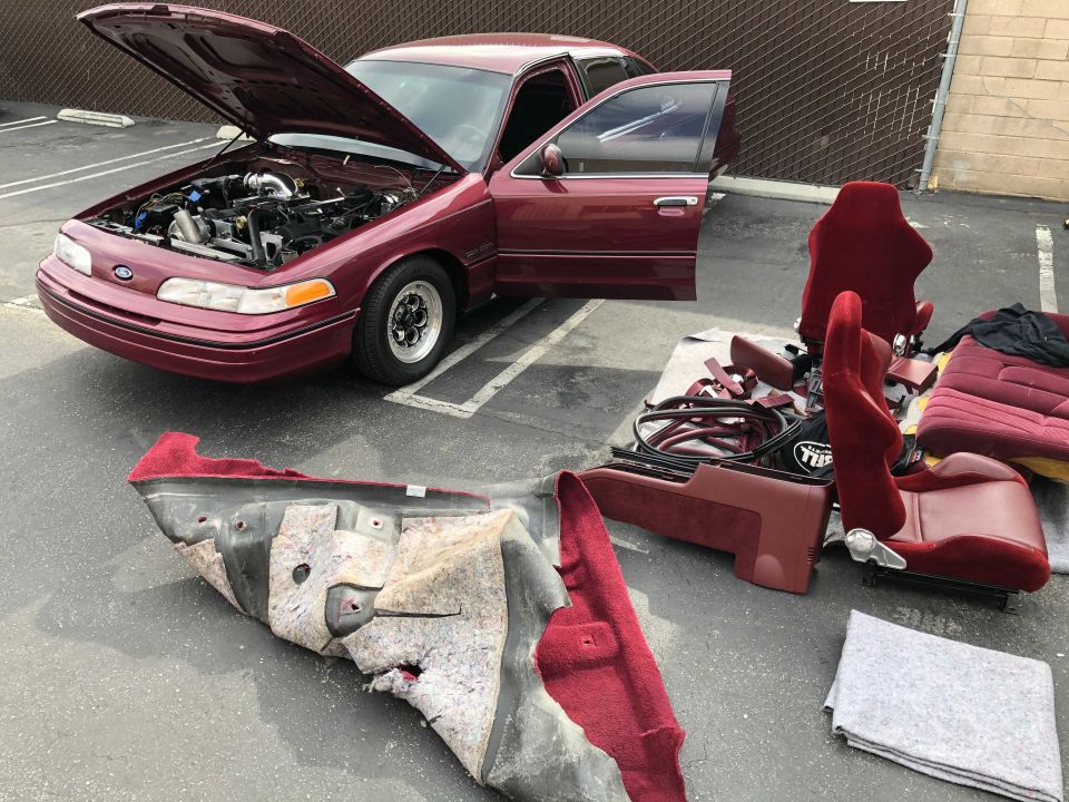 Maroon 1992 Ford Crown Victoria with engine exposed and interior parts disassembled