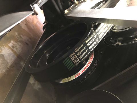 1992 Ford Crown Victoria - Close-up view of a black serpentine belt and a "SUPER DAMPER" pulley, part of an engine's accessory drive system.
