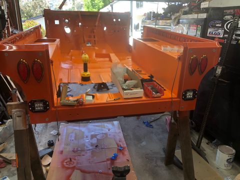 1992 Jeep Wrangler - The rear tub of an orange Jeep CJ/YJ is undergoing restoration, mounted on sawhorses.