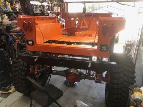 1992 Jeep Wrangler - Jeep CJ-7 body in orange, modified with large tires and a new bumper, during restoration.