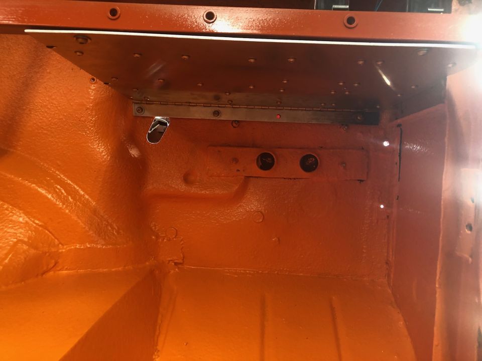 Orange painted interior of a vehicle, possibly a Jeep, showing metal bracing and mounting points