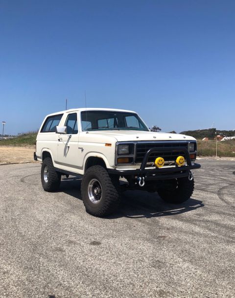 1981 Ford Bronco - This modified Ford Bronco features a prominent brush guard and oversized tires, suggesting off-road use.