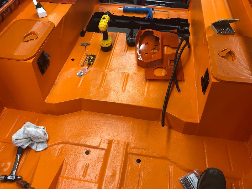 Orange interior floor with tools, including a drill and hammer