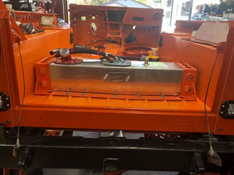 1992 Jeep Wrangler - A custom fuel tank is installed in the rear of an orange-painted vehicle, likely undergoing modification.