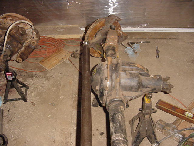 Differential axle assembly on jack stands with orange wiring and tools