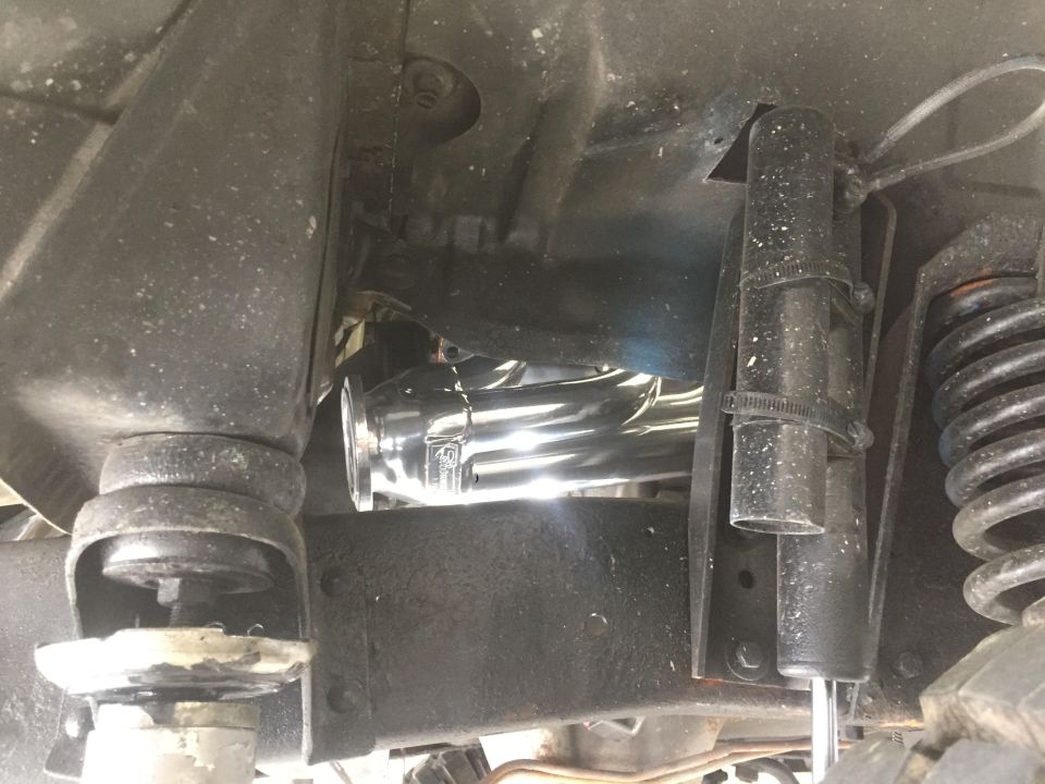 Chrome exhaust headers and shock absorber on vehicle undercarriage