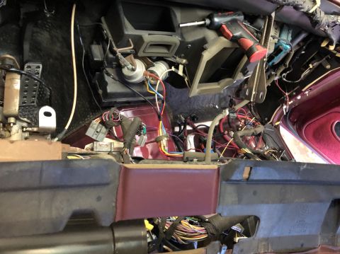 1992 Ford Crown Victoria - Car dashboard disassembled, revealing complex wiring and internal components. A power drill rests on top of the dash.