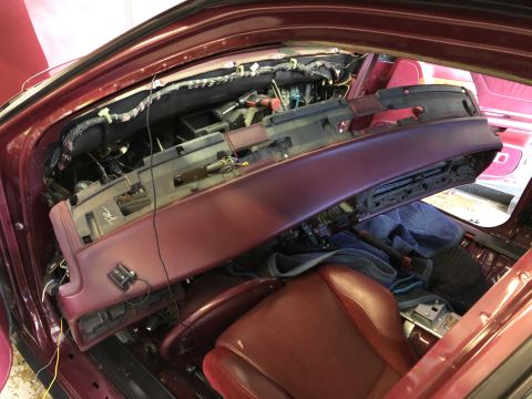 1992 Ford Crown Victoria - The dashboard of a car is disassembled, revealing the complex wiring and HVAC systems beneath.