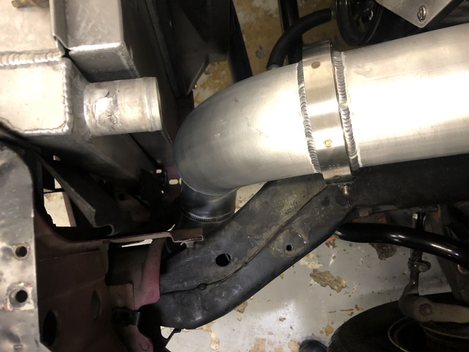 Aluminum radiator and large diameter intake pipe with visible welds and clamps
